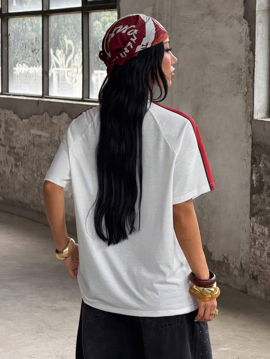 Yellow oversized graphic t-shirt featuring Brazil letter print on the front with contrast raglan sleeves and side stripe detailing.
