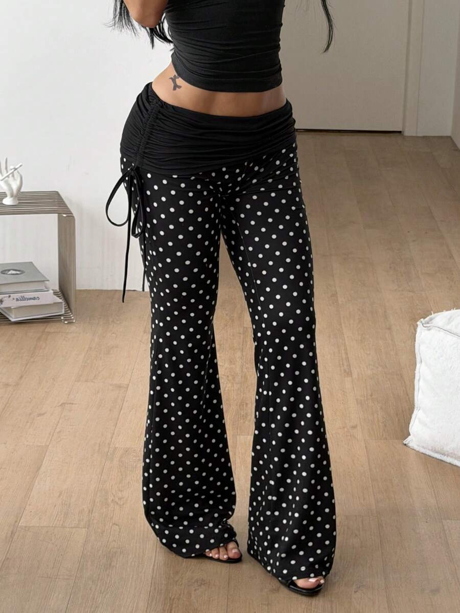 Women's black and white polka dot flare leg pants with side drawstring and ruched details