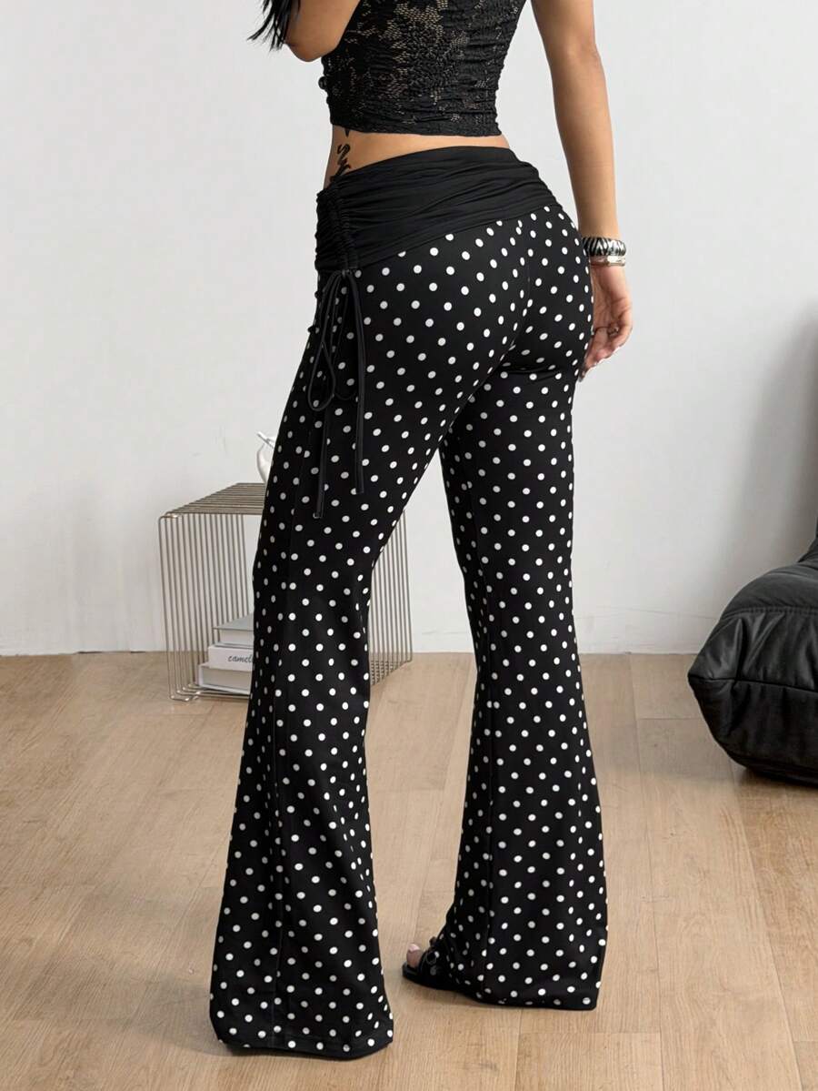 Women's black and white polka dot flare leg pants with side drawstring and ruched details