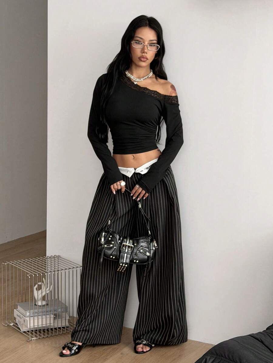 Women's slim fit long sleeve knit top featuring an asymmetrical neckline and grommet eyelet detail
