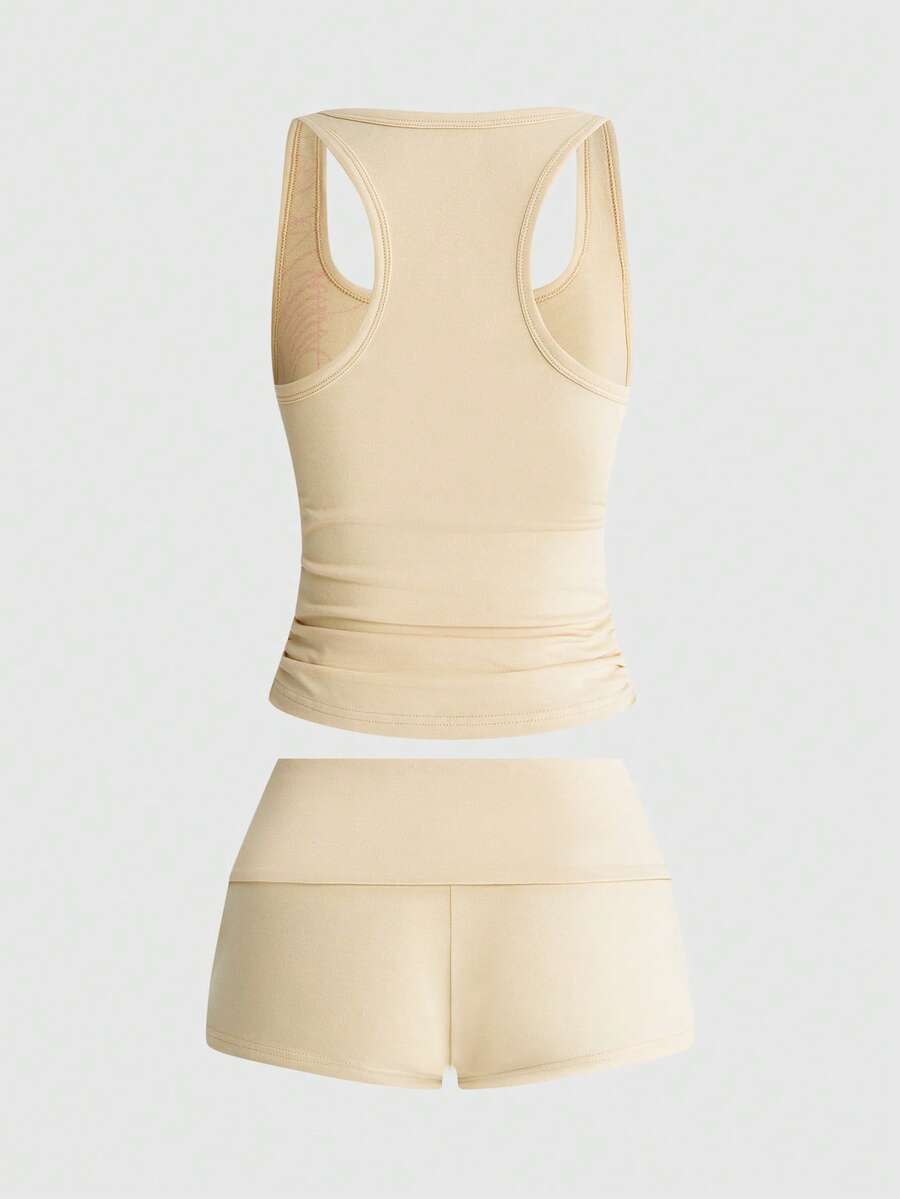 Punk-inspired two-piece set with a fitted scoop neck slogan tank top featuring cross and rhinestone details paired with ultra low waist mini shorts.