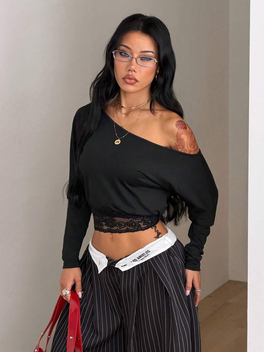 Women's black long sleeve t-shirt featuring delicate contrast lace details and a boat neckline in a knitted stretch fabric.