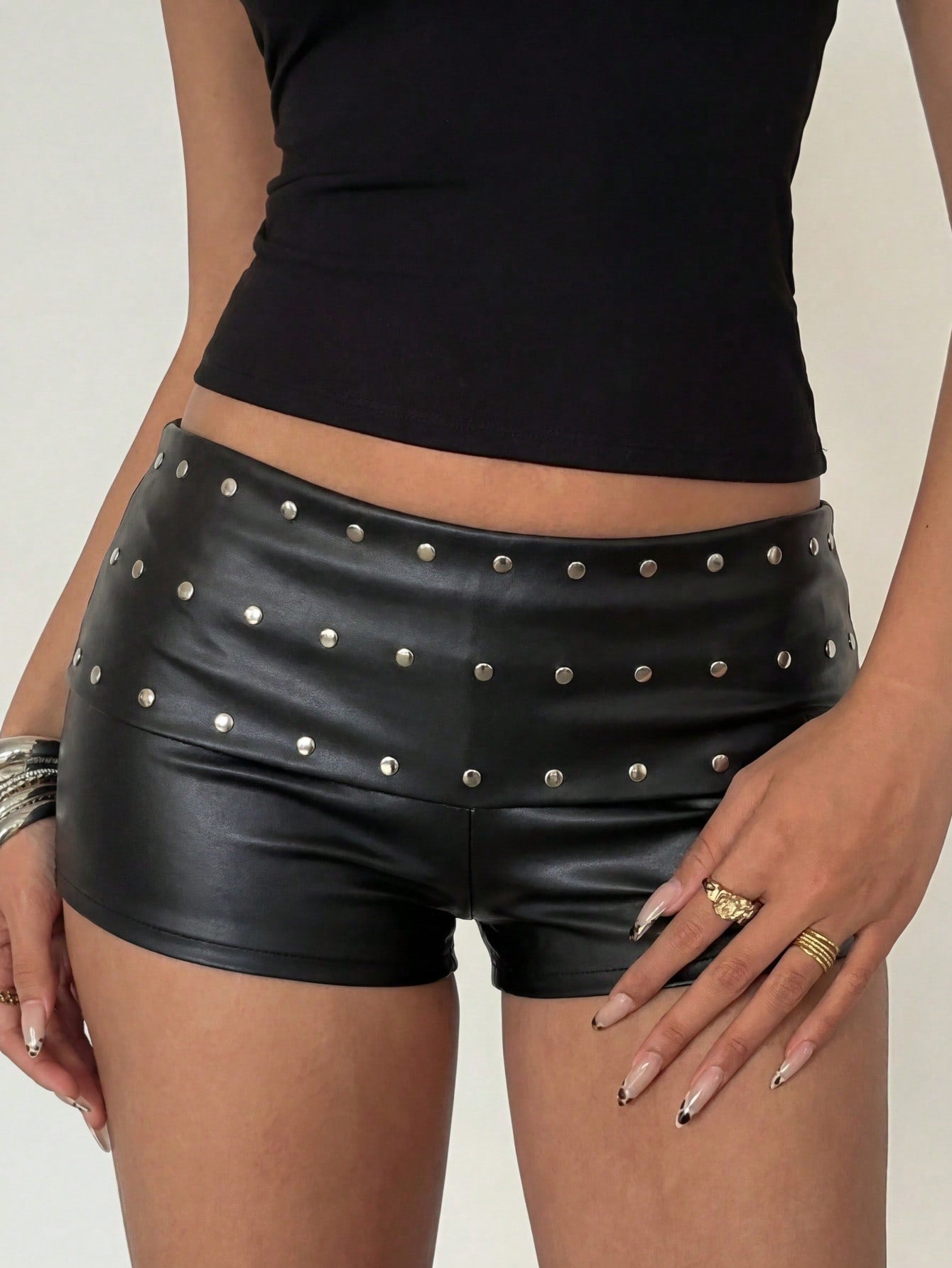 Women's studded PU ultra low waist mini shorts with zipper fly closure, skinny fit, mini length, and plain unlined design.