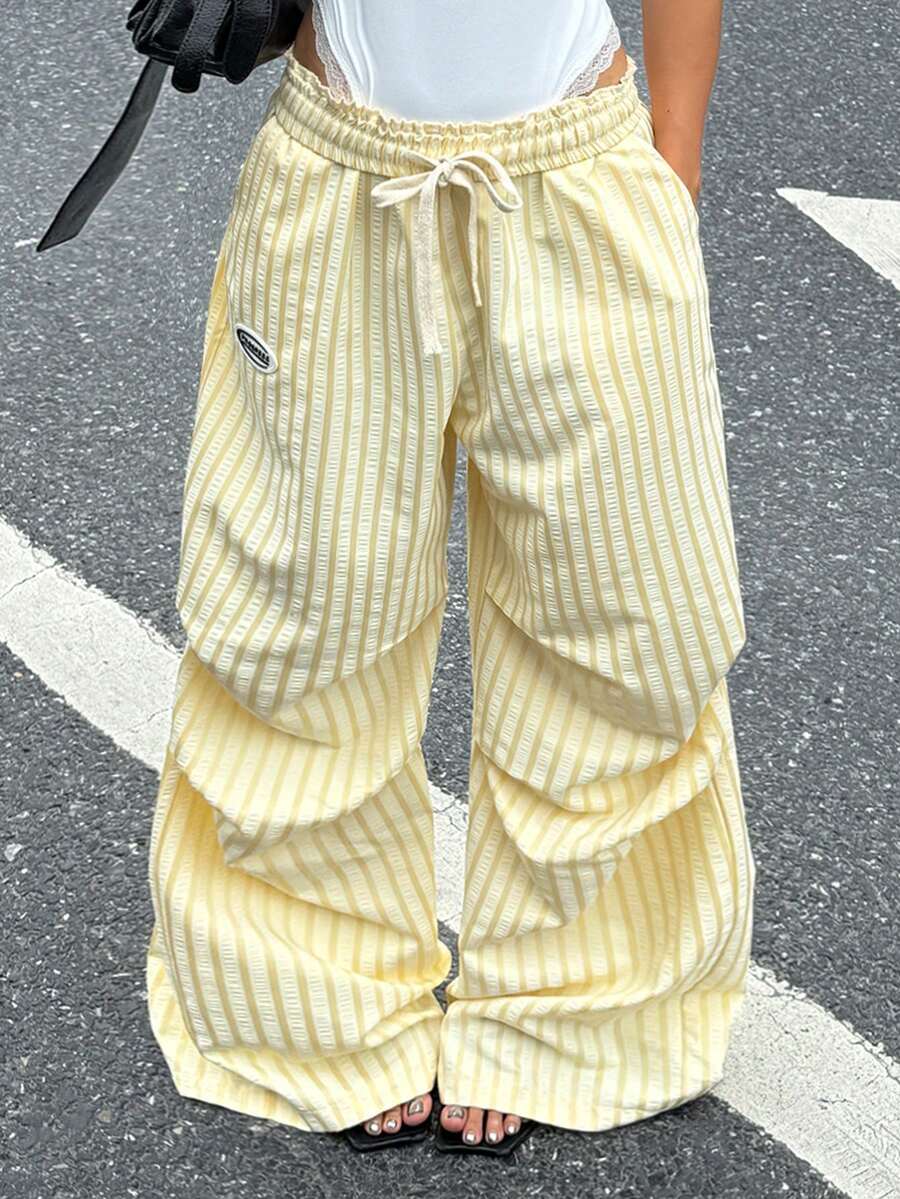 Women's black and white striped wide leg pants featuring an elastic drawstring waistband, side pockets, and a loose straight leg fit.