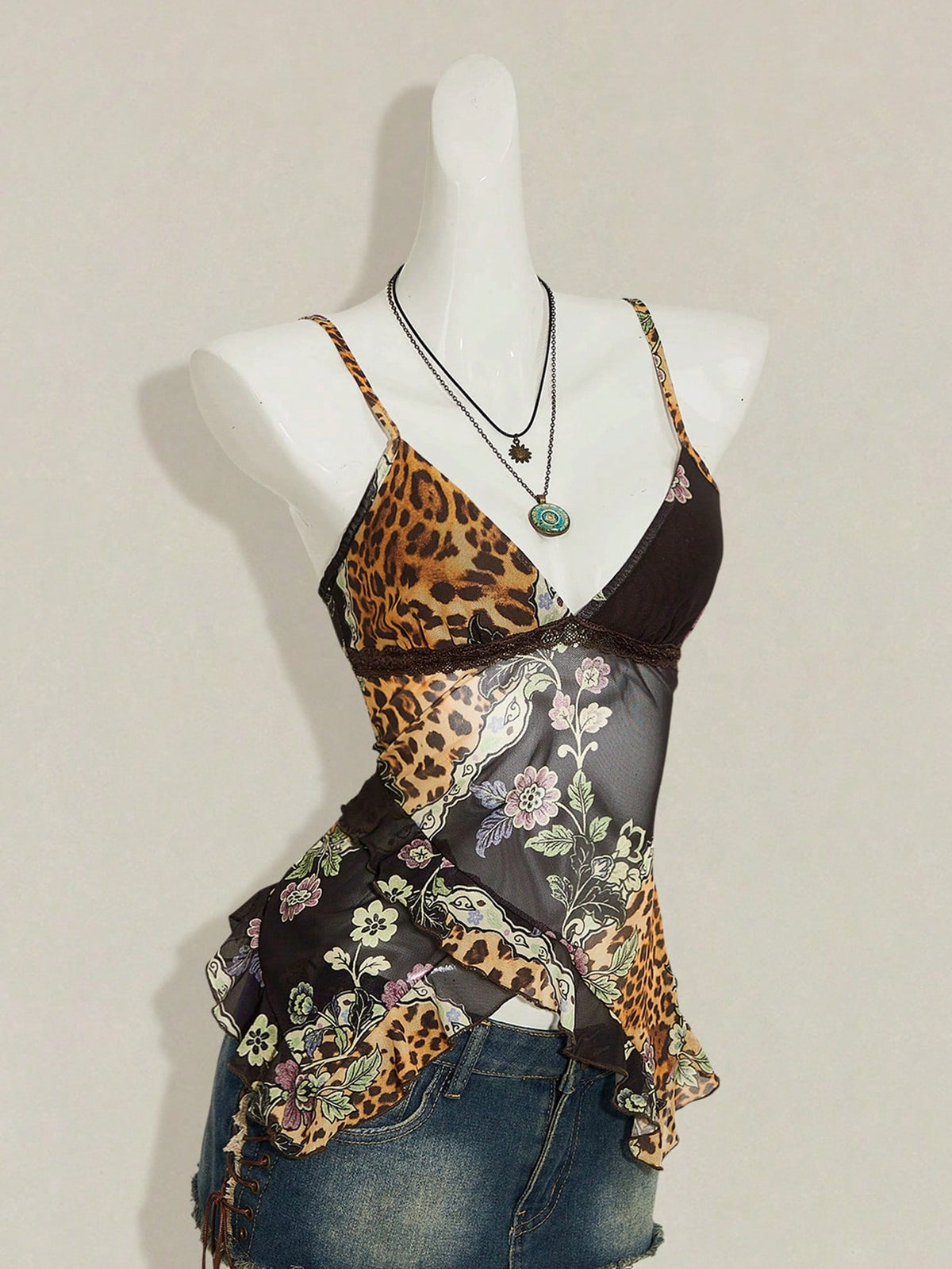Women's graphic print camisole top featuring thin spaghetti straps, a backless cut, and an asymmetrical hem.