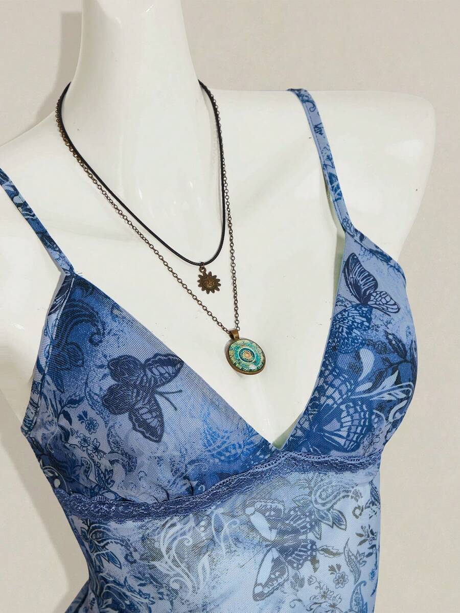 Women's graphic print camisole top featuring thin spaghetti straps, a backless cut, and an asymmetrical hem.