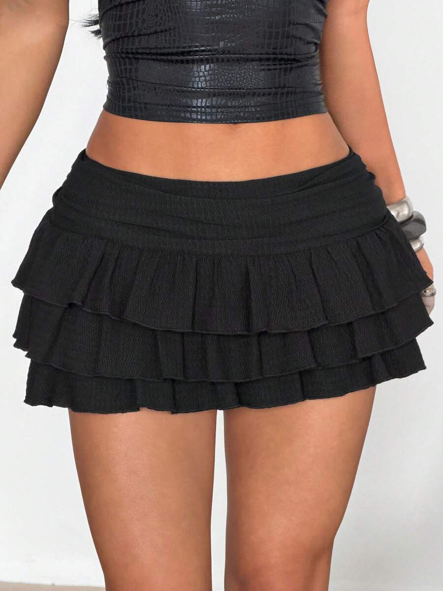 Women's white low waist tiered mini skirt featuring ruched detailing and a slight-stretch knitted fabric.