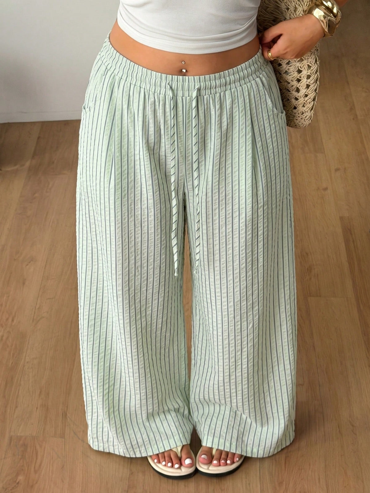 Plus size women's striped loose straight leg cropped pants with pleated detailing and side pockets