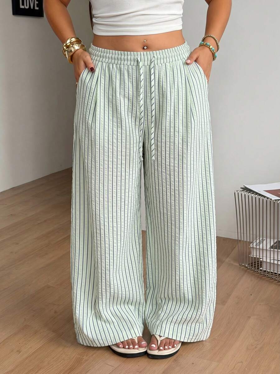 Plus size women's striped loose straight leg cropped pants with pleated detailing and side pockets