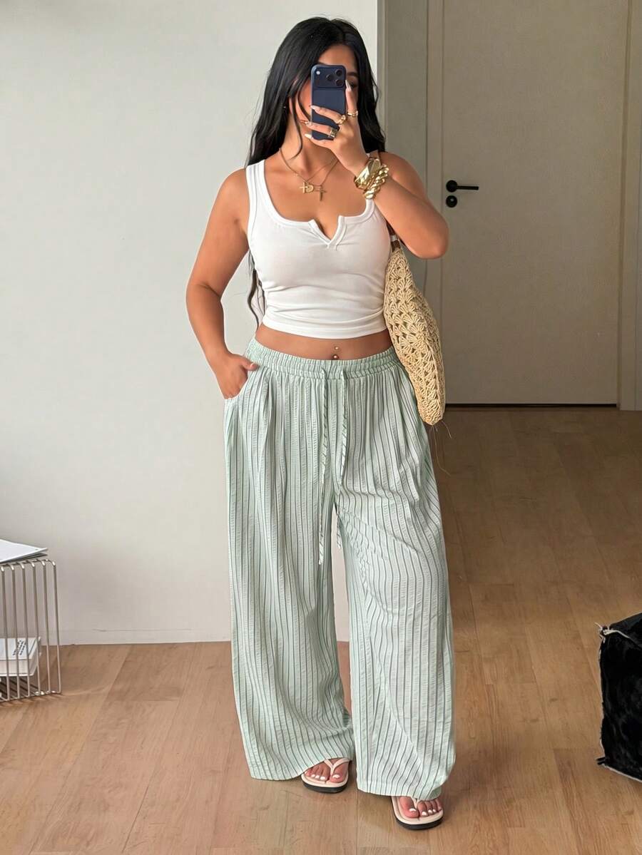 Plus size women's striped loose straight leg cropped pants with pleated detailing and side pockets