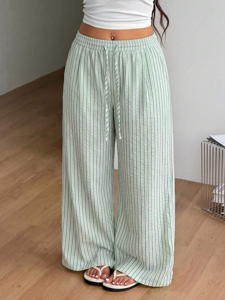 Plus size women's striped loose straight leg cropped pants with pleated detailing and side pockets