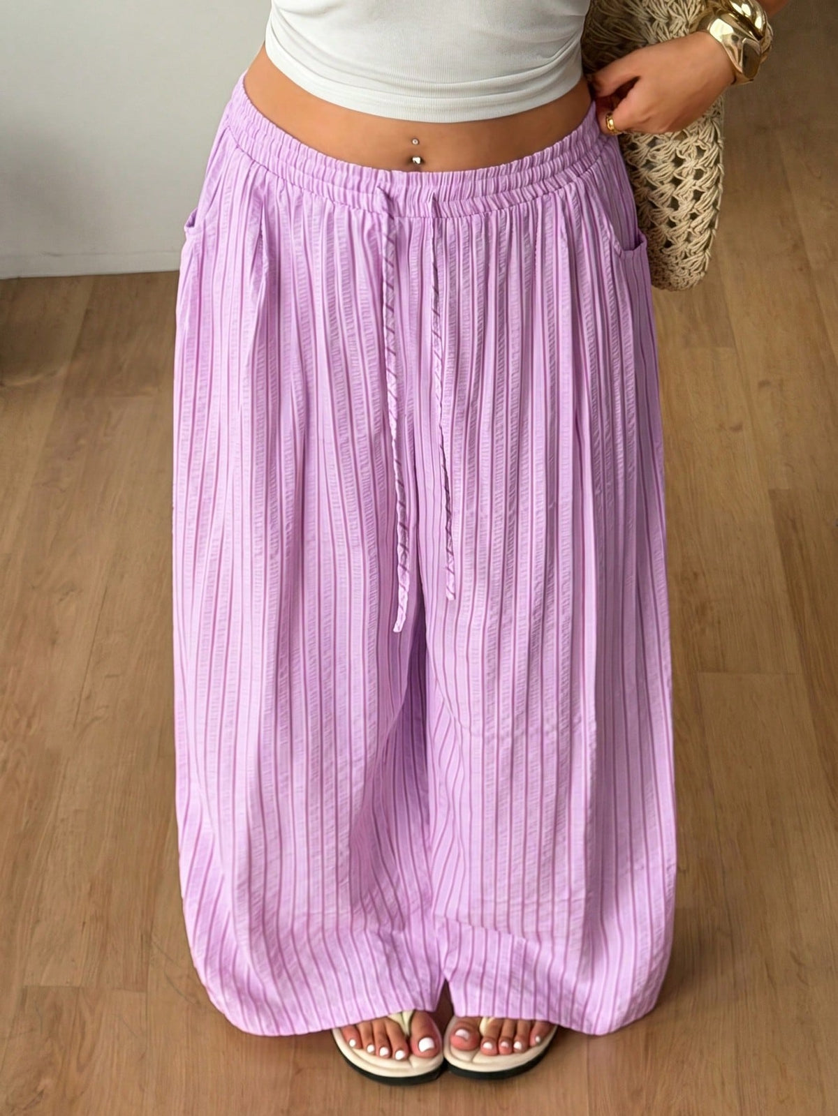 Plus size women's striped loose straight leg cropped pants with pleated detailing and side pockets