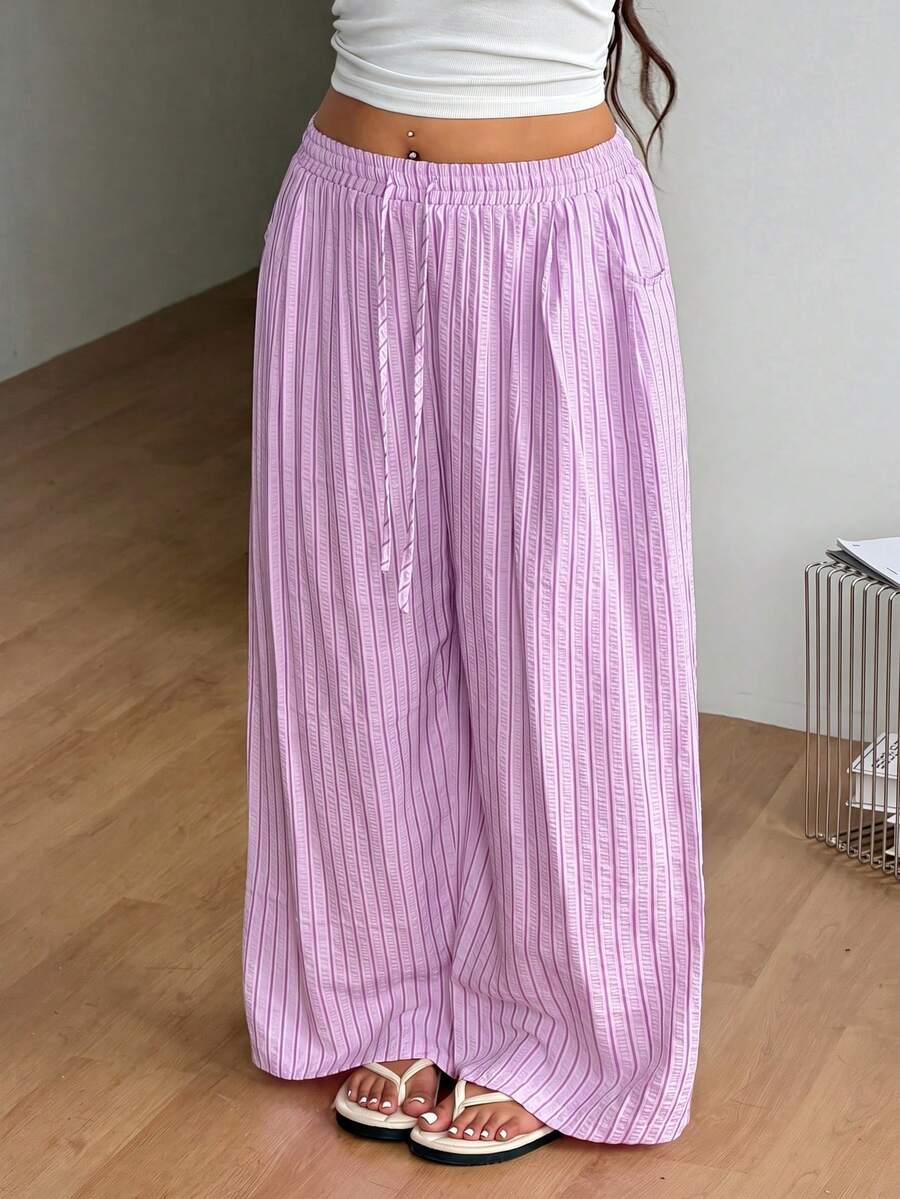Plus size women's striped loose straight leg cropped pants with pleated detailing and side pockets