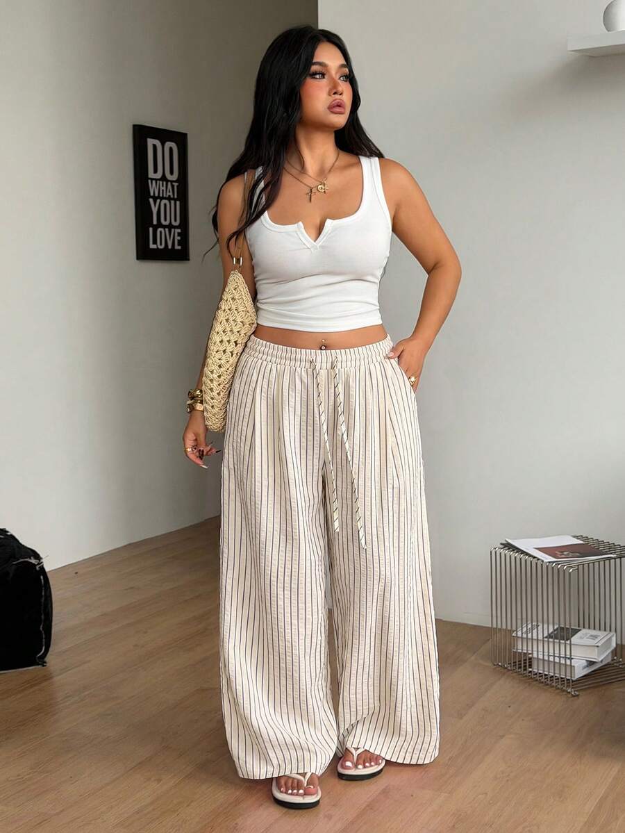 Plus size women's striped loose straight leg cropped pants with pleated detailing and side pockets