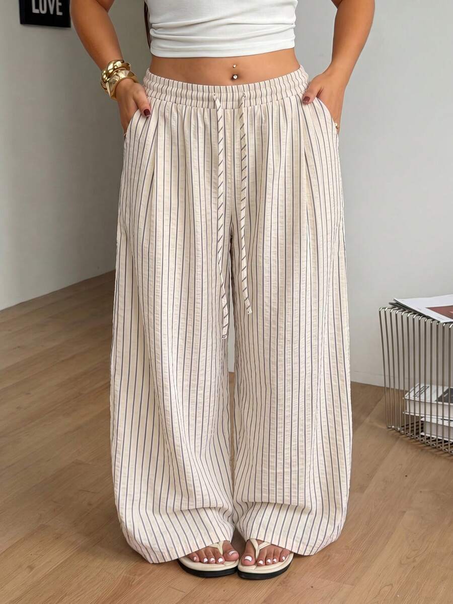Plus size women's striped loose straight leg cropped pants with pleated detailing and side pockets