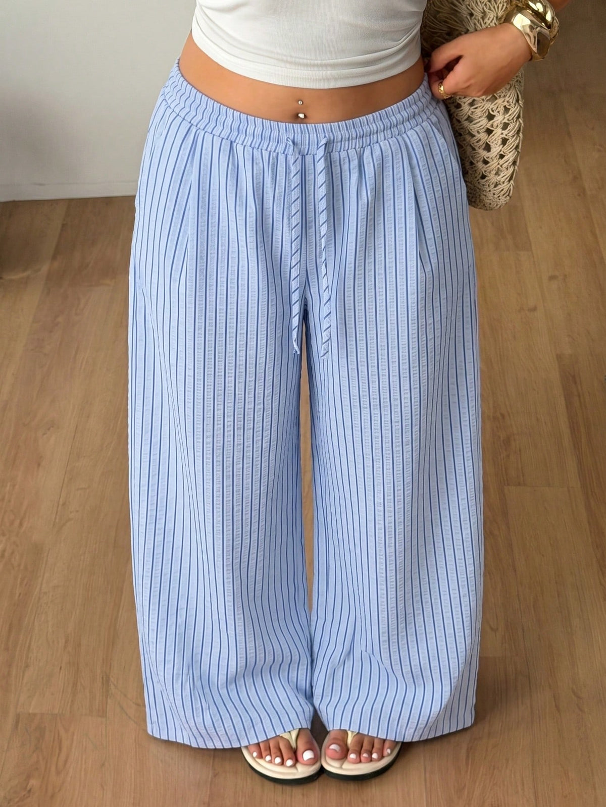 Plus size women's striped loose straight leg cropped pants with pleated detailing and side pockets