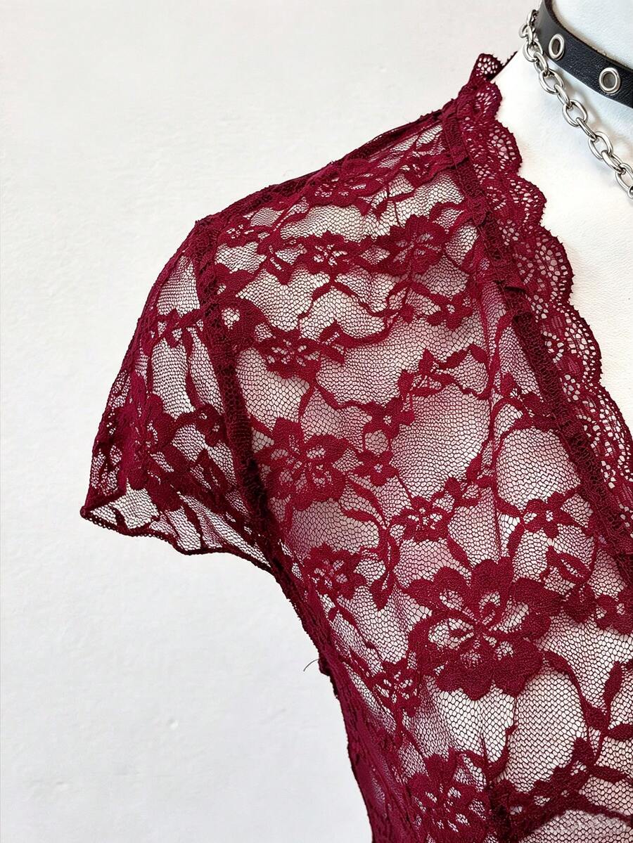 Women's semi-sheer deep V-neck top featuring cap sleeves, contrast lace trimming, and a lace-up front detail.