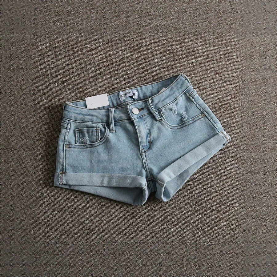 Women's low-waist shorts with ripped hem, asymmetrical detail, straight-leg cut, and pockets.