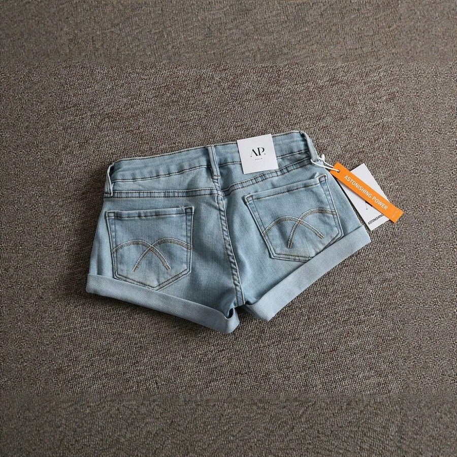 Women's low-waist shorts with ripped hem, asymmetrical detail, straight-leg cut, and pockets.