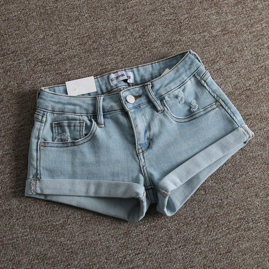 Women's low-waist shorts with ripped hem, asymmetrical detail, straight-leg cut, and pockets.