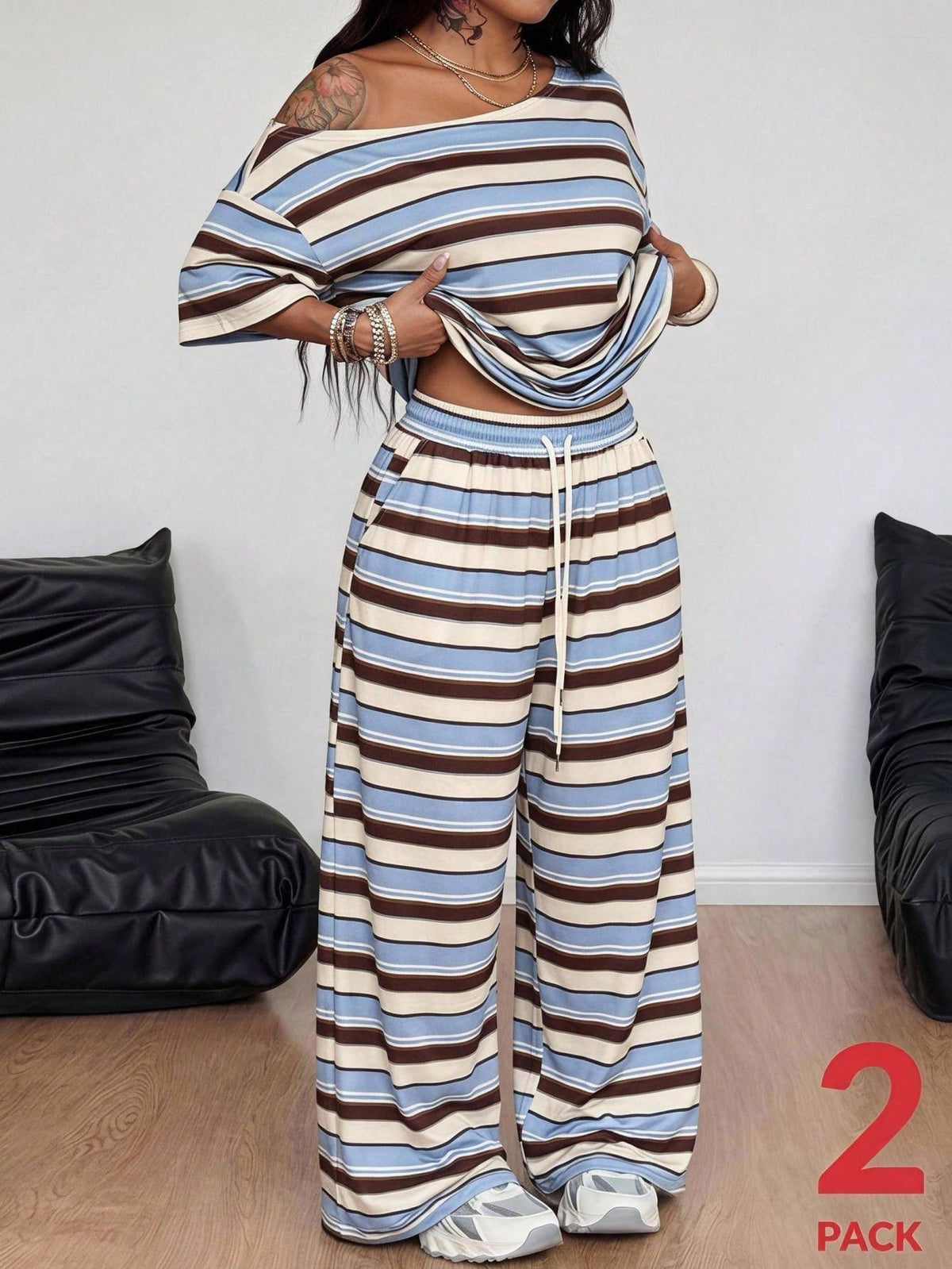 Striped two-piece casual outfit featuring an asymmetrical off-shoulder short-sleeve top and matching loose wide-leg pants with side pockets.