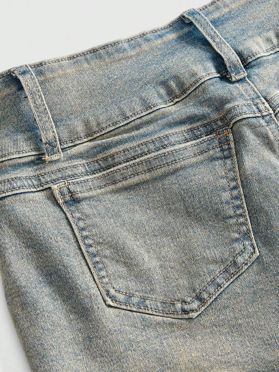 Front view of women's ultra low waist denim mini shorts with double metal button accents and zipper fly