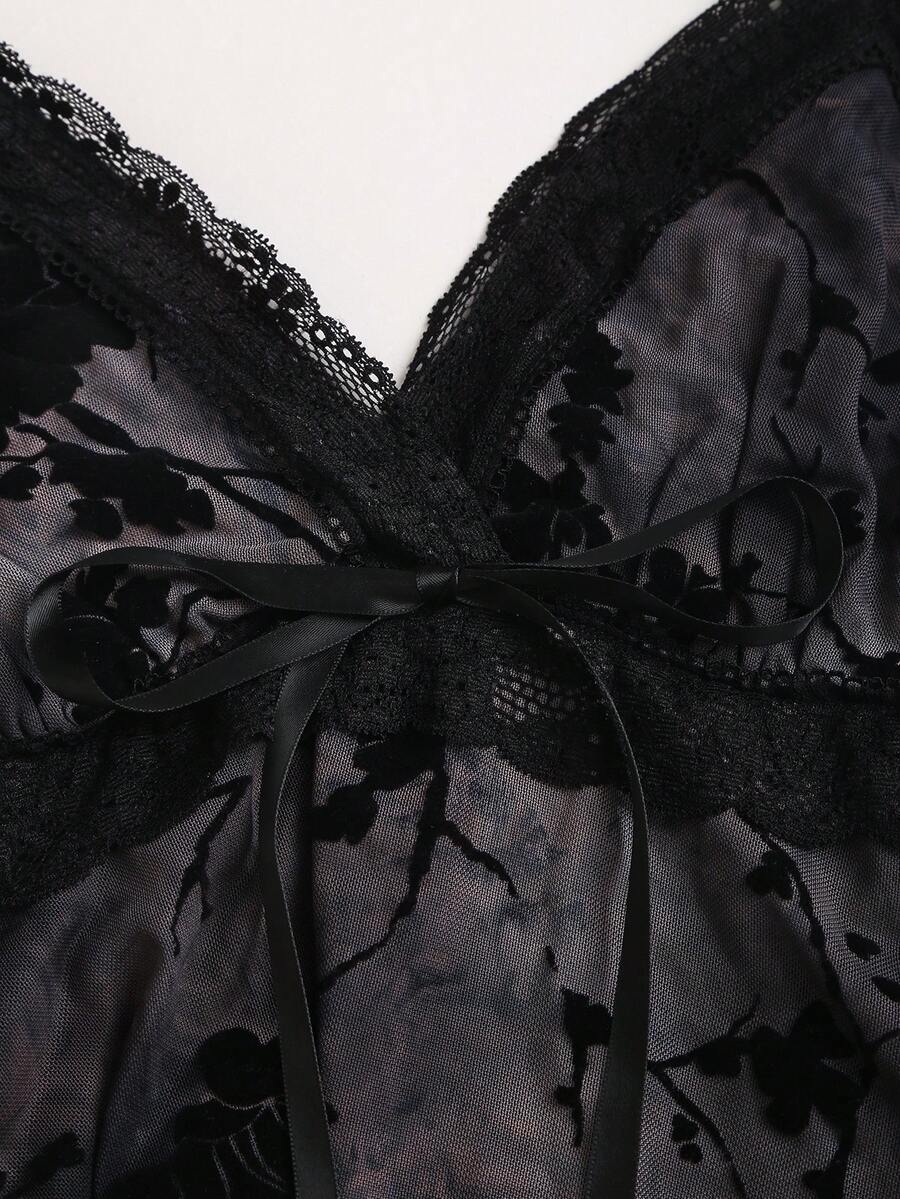 Women's black spaghetti strap tank top featuring contrast lace details, asymmetric ruffle hem, and slim fit design.