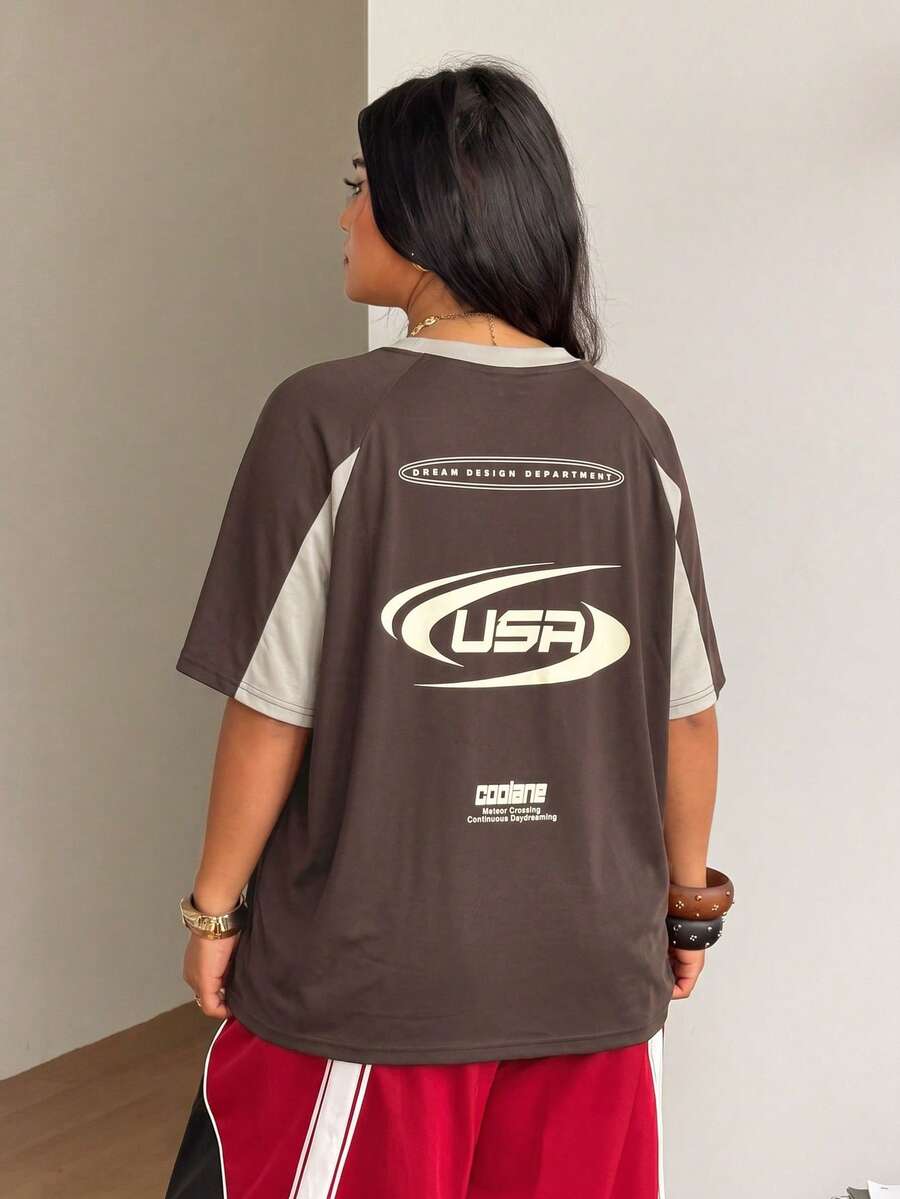 Unisex plus size oversized jersey t-shirt in brown featuring a round neck, short raglan sleeves with contrast binding, and a front letter graphic print.
