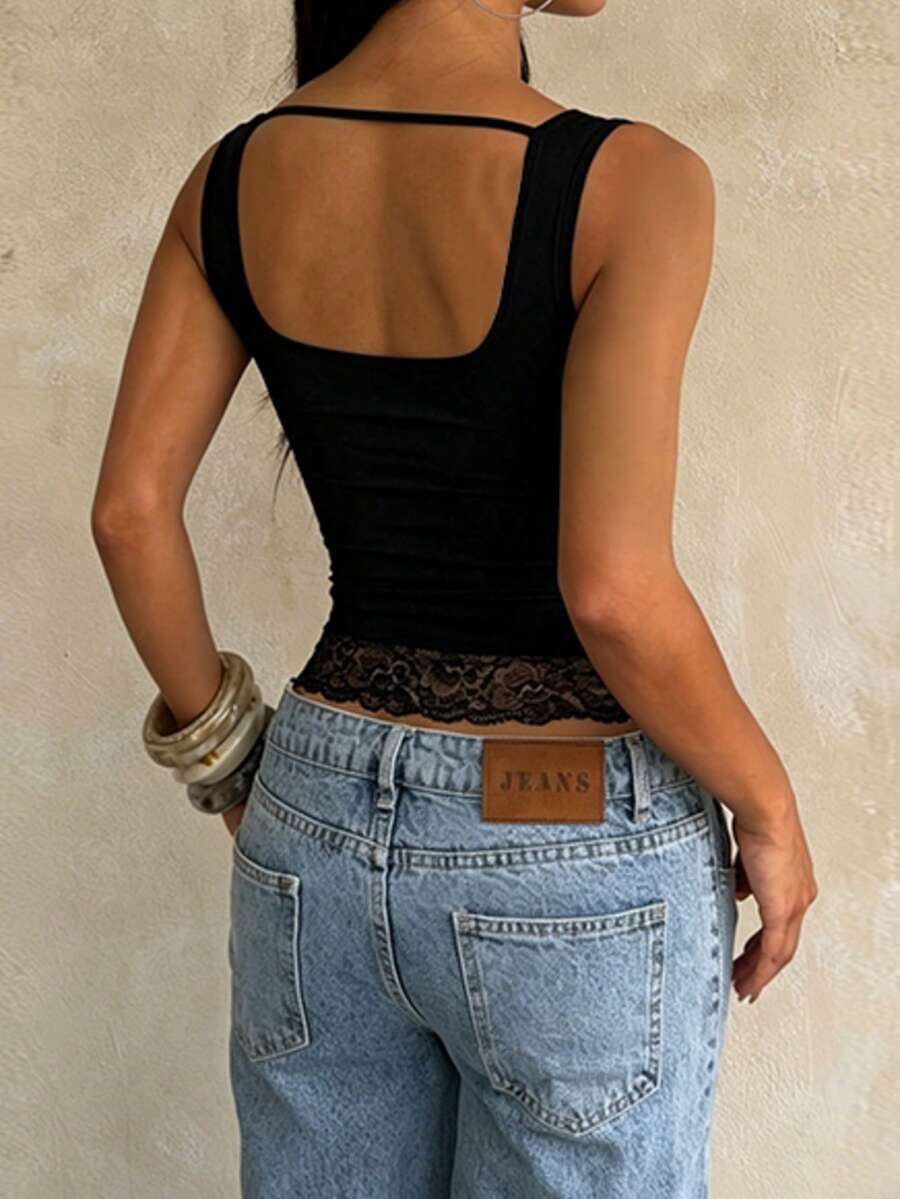 Women's white sleeveless crop tank top with contrast lace details, strap neckline, and graphic plant pattern in a slim fit.