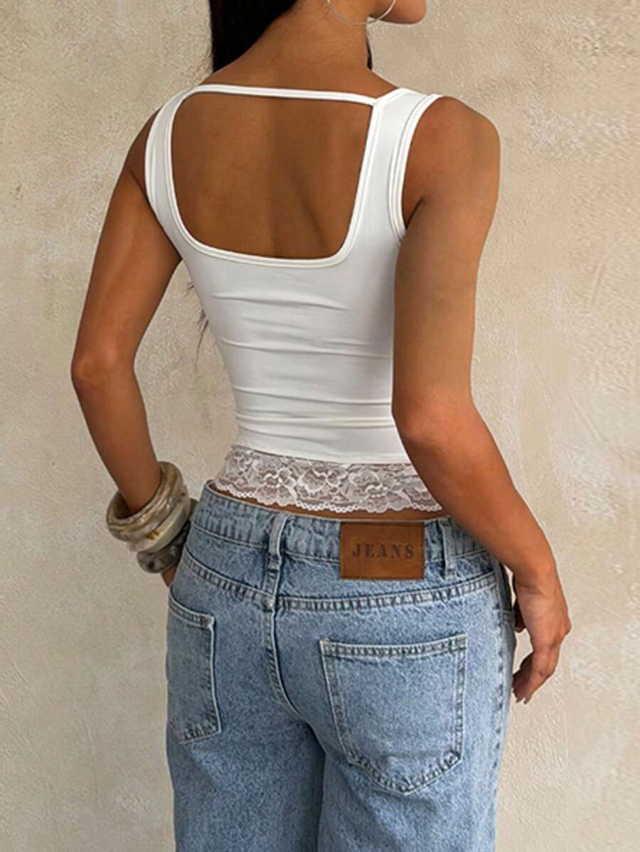 Women's white sleeveless crop tank top with contrast lace details, strap neckline, and graphic plant pattern in a slim fit.