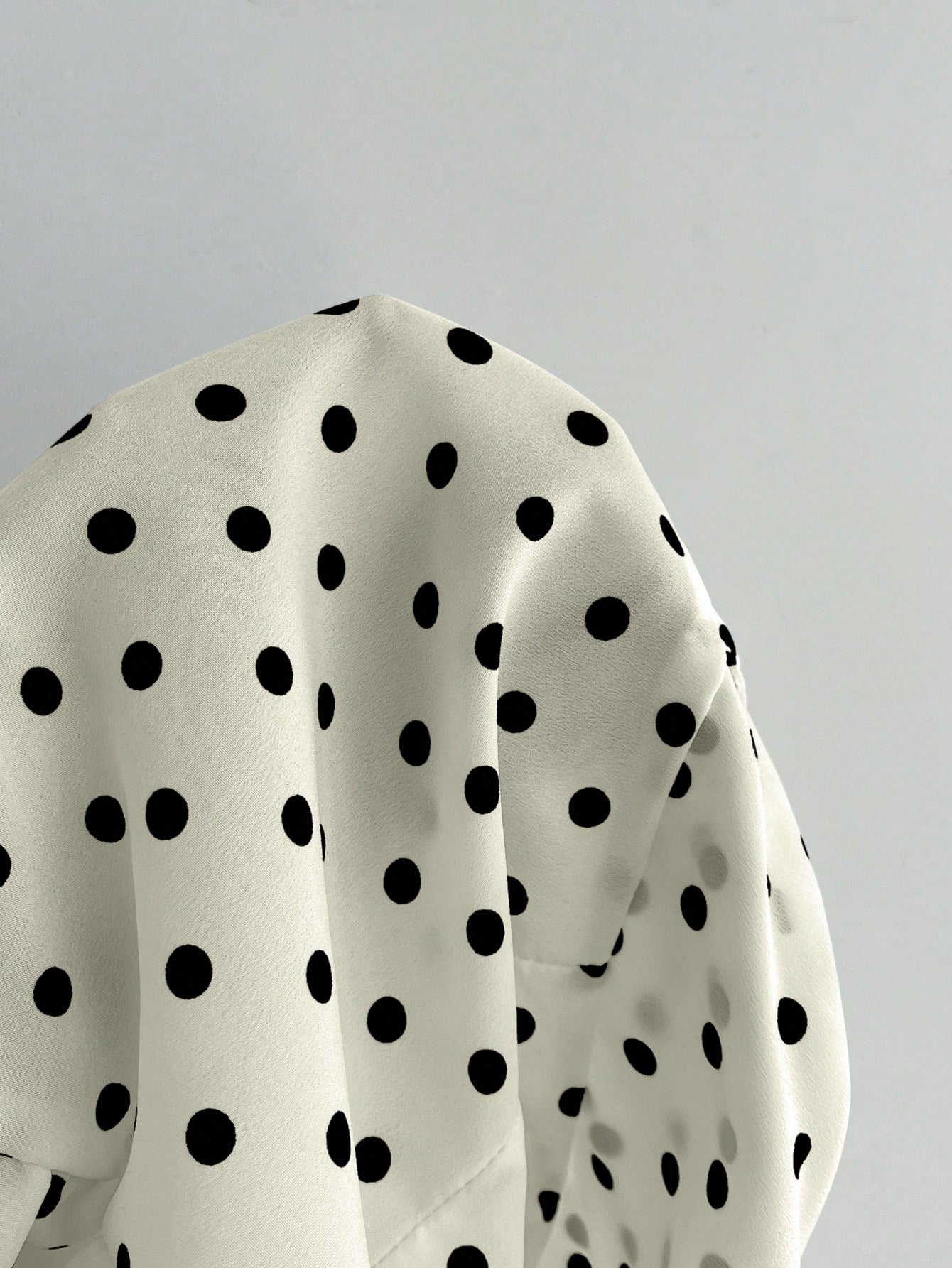 Women's polka dot halter camisole with bow bust detail, ruched and shirred design, slim crop fit, and flared ruffle hem.