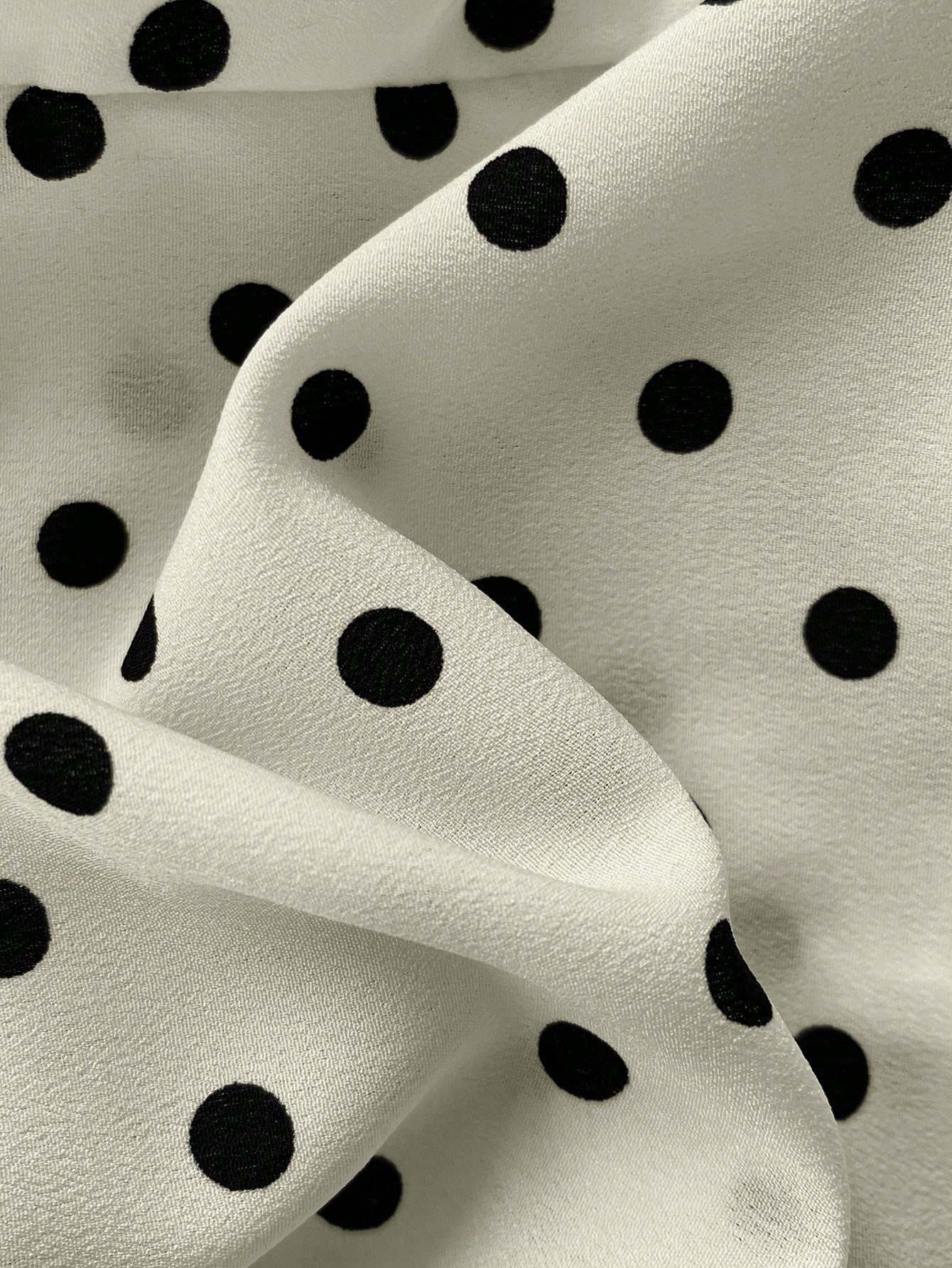 Women's polka dot halter camisole with bow bust detail, ruched and shirred design, slim crop fit, and flared ruffle hem.