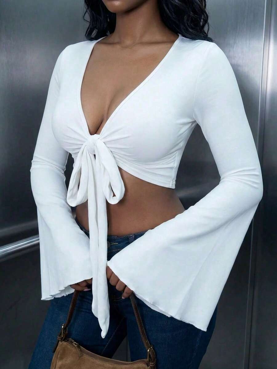 Women's mint blue cropped long sleeve top featuring a deep V-neck and twist knot asymmetrical front hem.