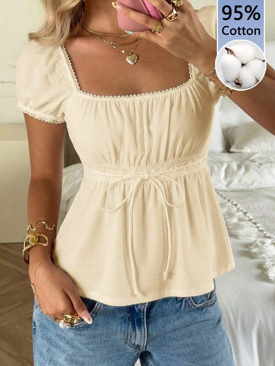 Women's black short puff sleeve top featuring a square neckline, ruched bust detail, and flared ruffle hem.