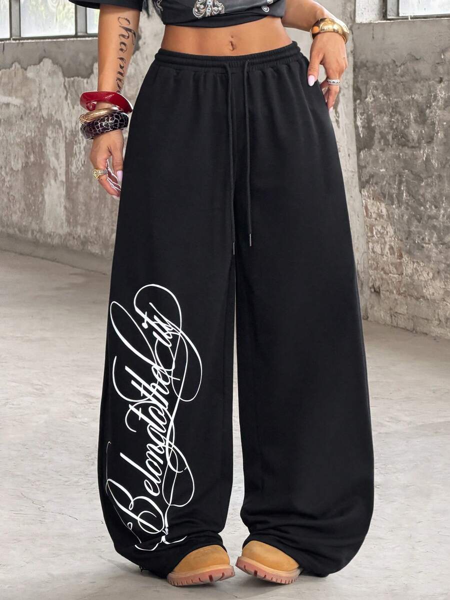 Women's loose fit wide leg graphic sweatpants in light grey with an elastic drawstring waistband
