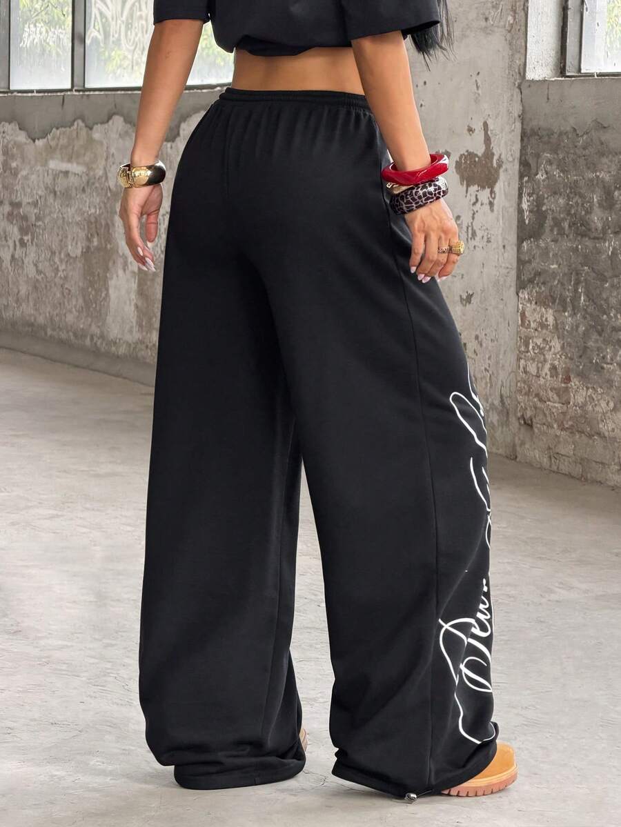Women's loose fit wide leg graphic sweatpants in light grey with an elastic drawstring waistband