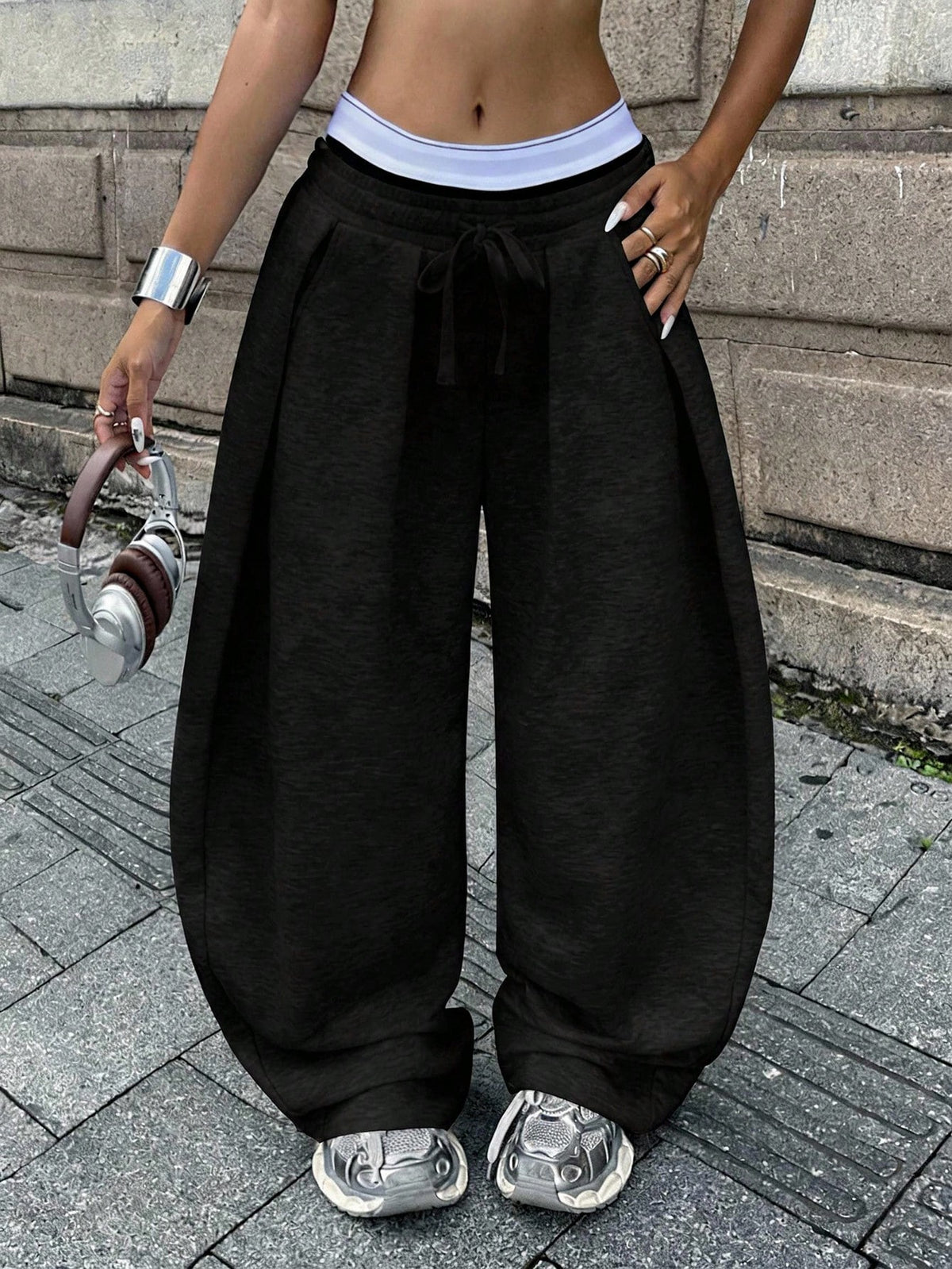 Women's casual black loose fit baggy banana pants featuring a low rise elastic drawstring waist and side pockets.