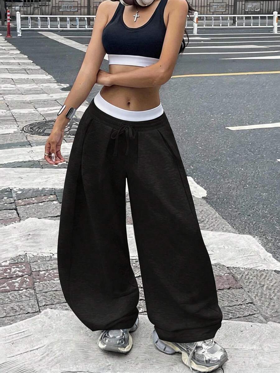 Women's casual black loose fit baggy banana pants featuring a low rise elastic drawstring waist and side pockets.