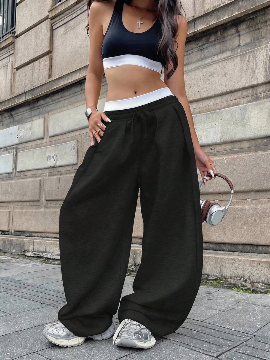 Women's casual black loose fit baggy banana pants featuring a low rise elastic drawstring waist and side pockets.