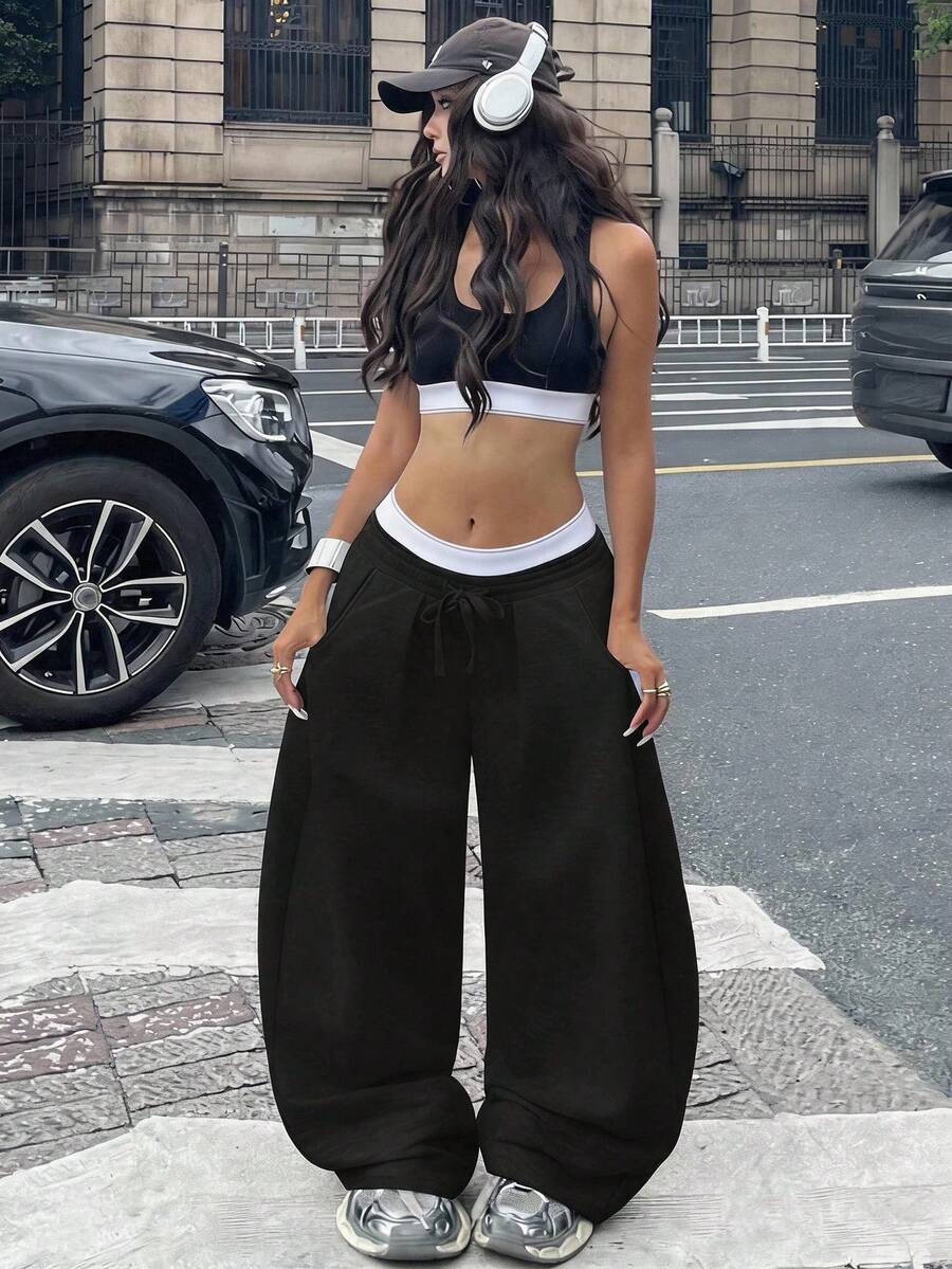 Women's casual black loose fit baggy banana pants featuring a low rise elastic drawstring waist and side pockets.