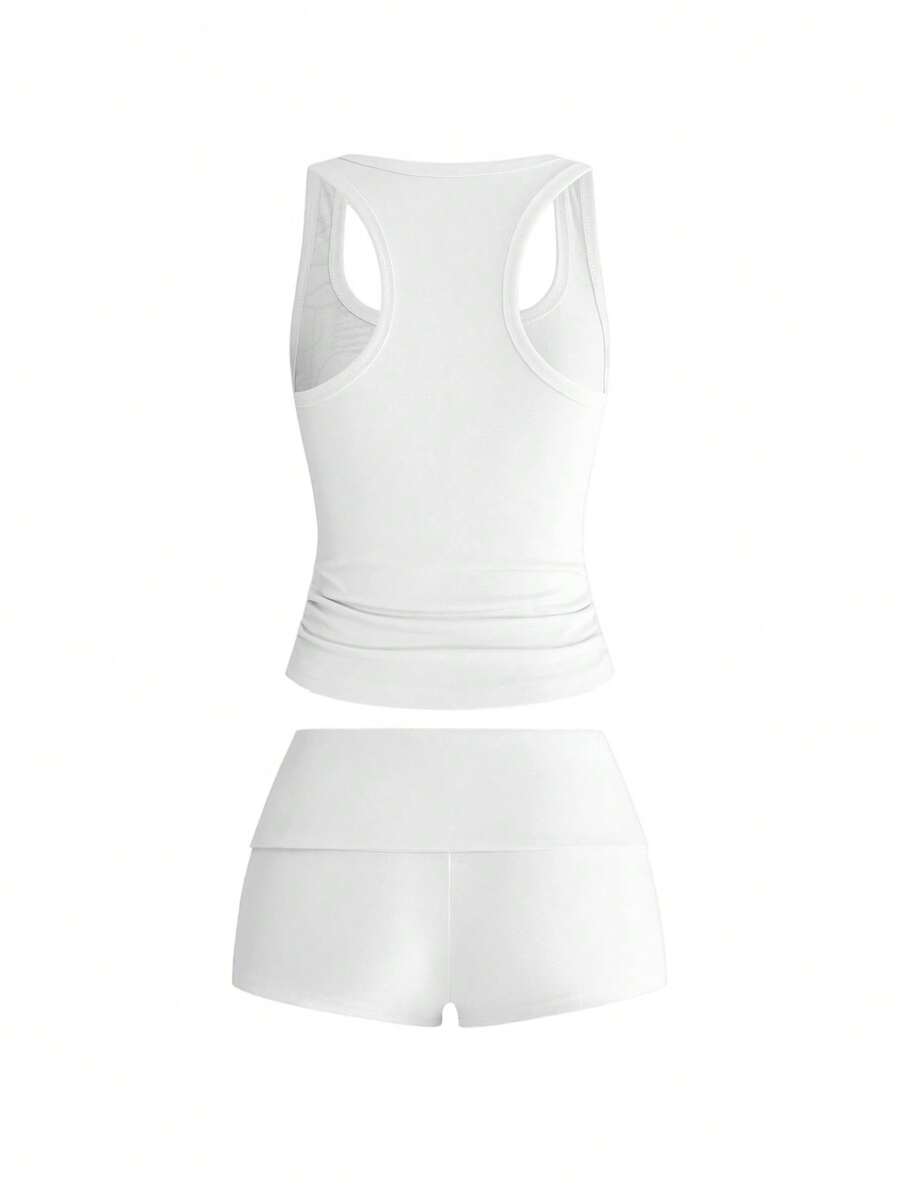 Punk-inspired two-piece set with a fitted scoop neck slogan tank top featuring cross and rhinestone details paired with ultra low waist mini shorts.