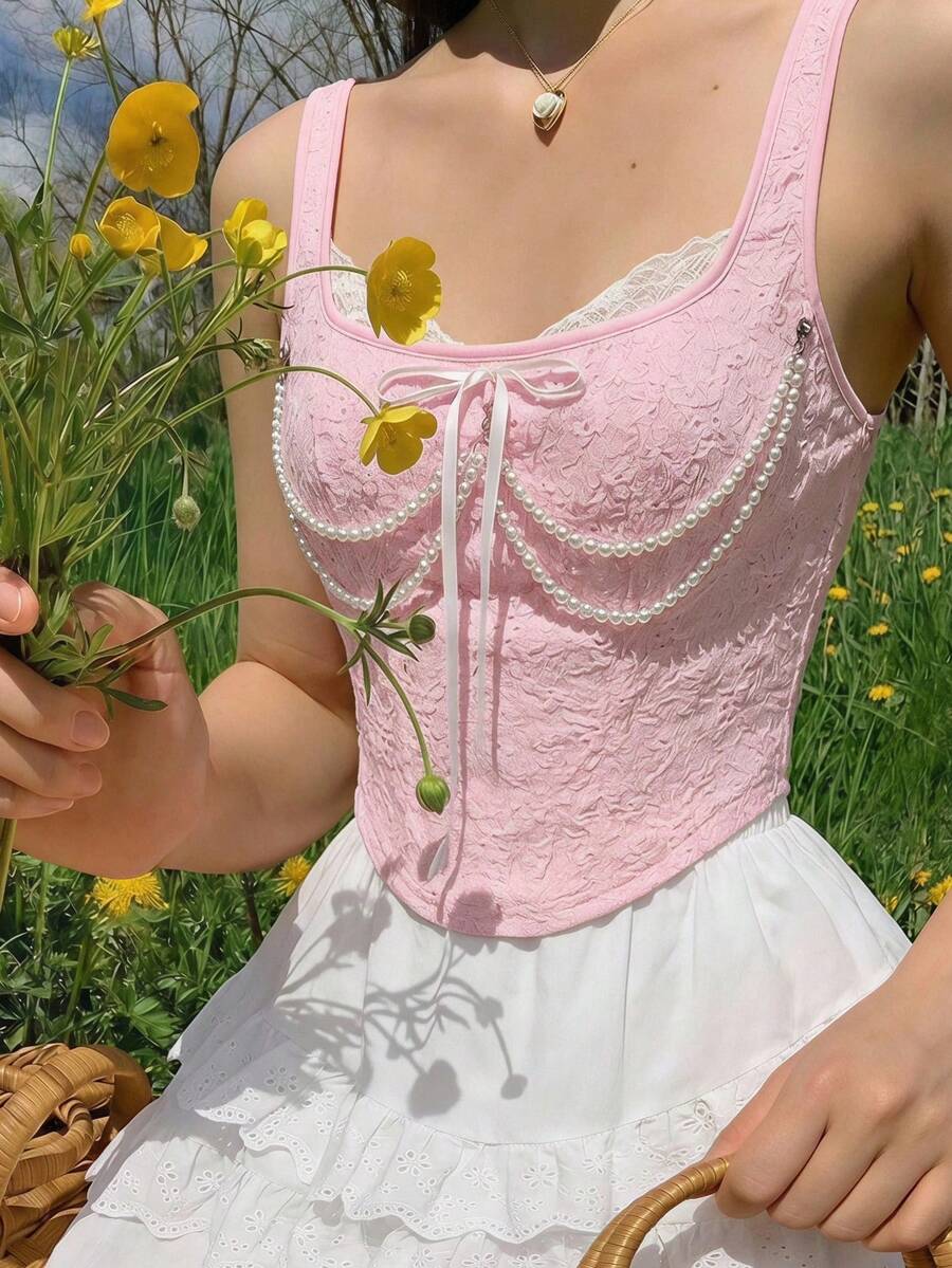 women's black wide-strap tank top featuring a lace collar, detachable bow chain decor with pearl details, and an asymmetrical hem.