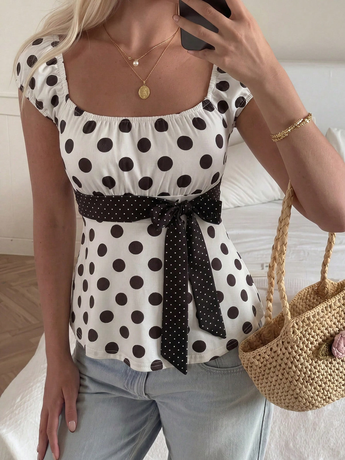 Women's short sleeve square neck polka dot top with ruched detailing, flared hem, and waist tie back.