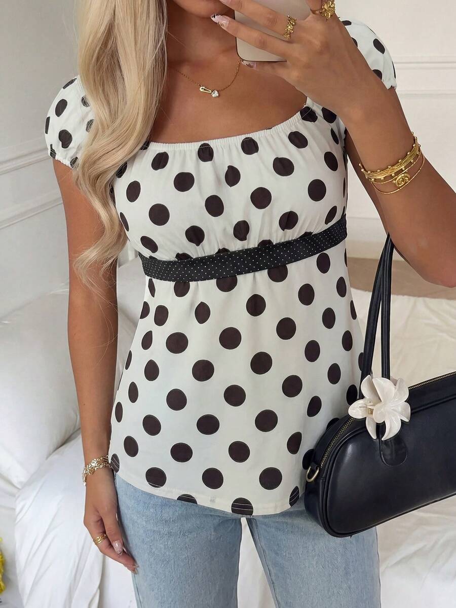Women's short sleeve square neck polka dot top with ruched detailing, flared hem, and waist tie back.