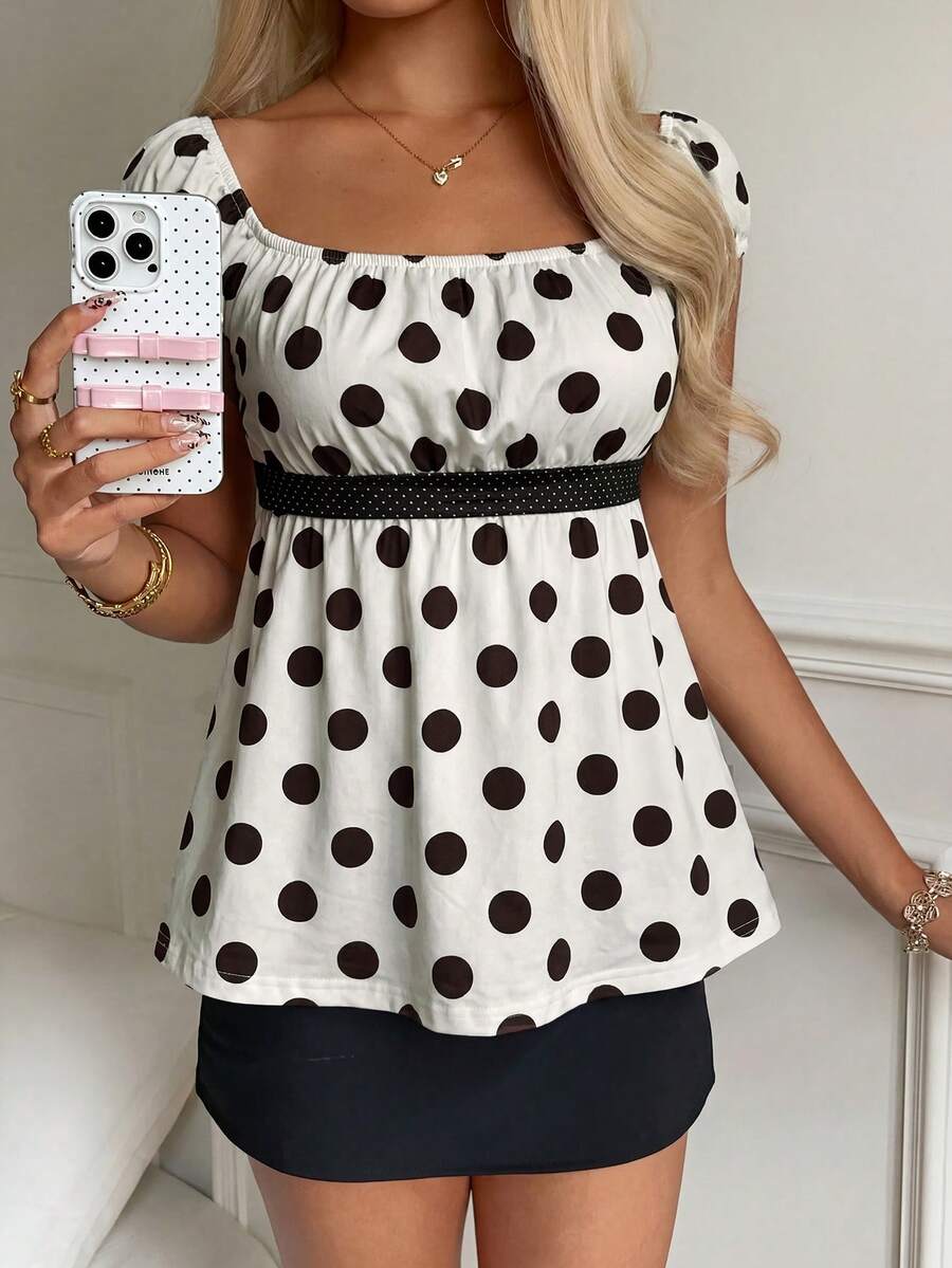 Women's short sleeve square neck polka dot top with ruched detailing, flared hem, and waist tie back.