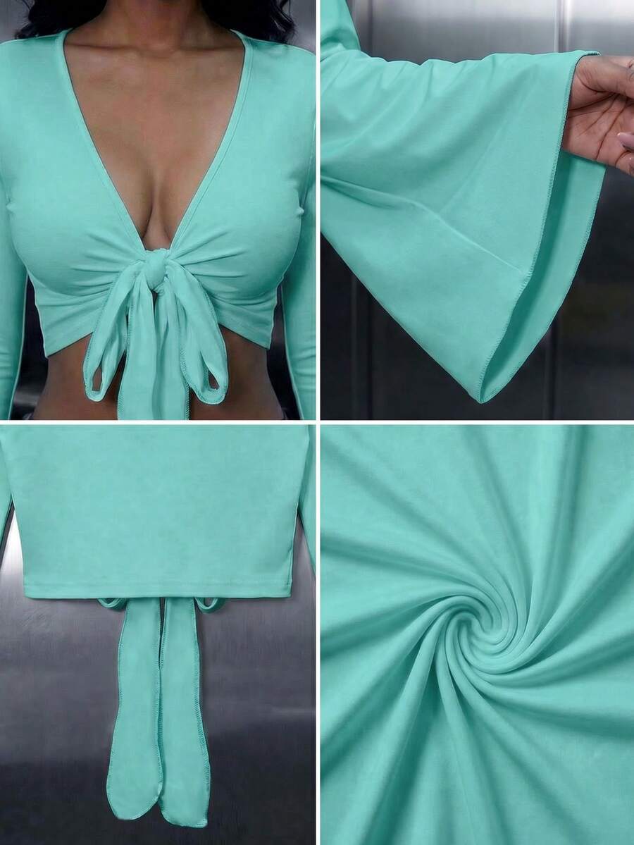 Women's mint blue cropped long sleeve top featuring a deep V-neck and twist knot asymmetrical front hem.