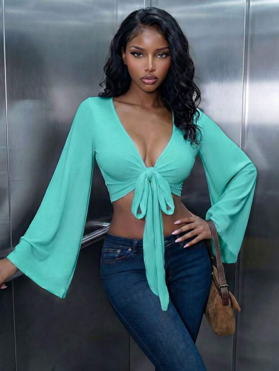 Women's mint blue cropped long sleeve top featuring a deep V-neck and twist knot asymmetrical front hem.