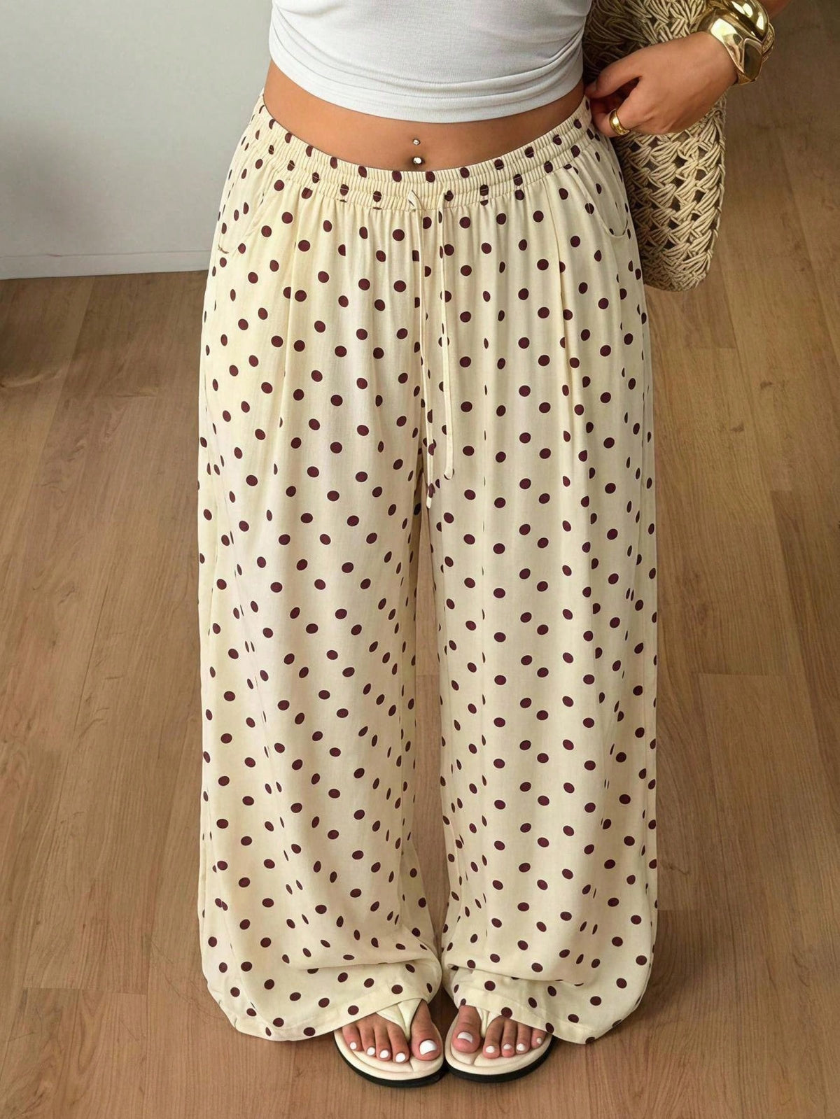 Women's loose straight leg cotton pants featuring a high waist with an adjustable drawstring knot and functional side pockets.