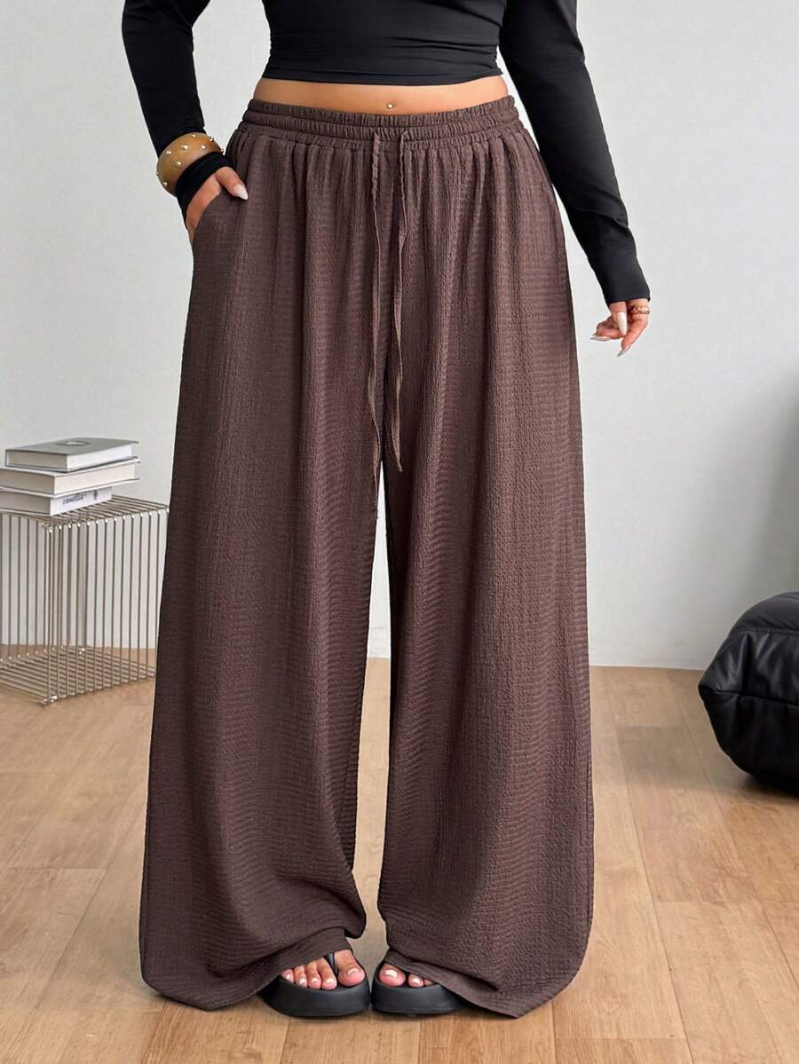 Women's loose straight leg cotton pants featuring a high waist with an adjustable drawstring knot and functional side pockets.