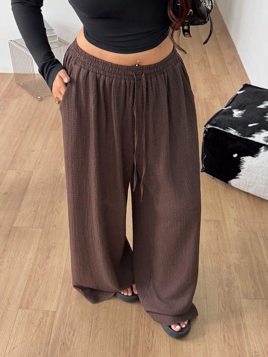Women's loose straight leg cotton pants featuring a high waist with an adjustable drawstring knot and functional side pockets.